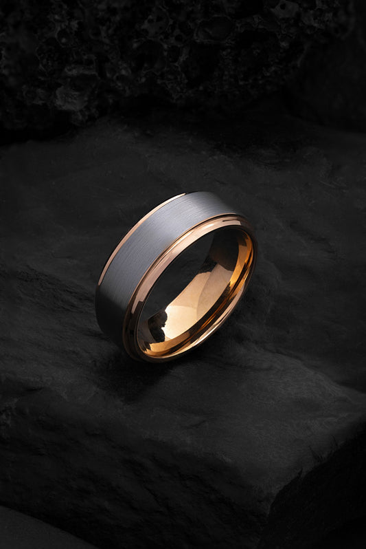 The Pegasus brushed gunmetal tungsten ring featuring a polished rose gold interior.