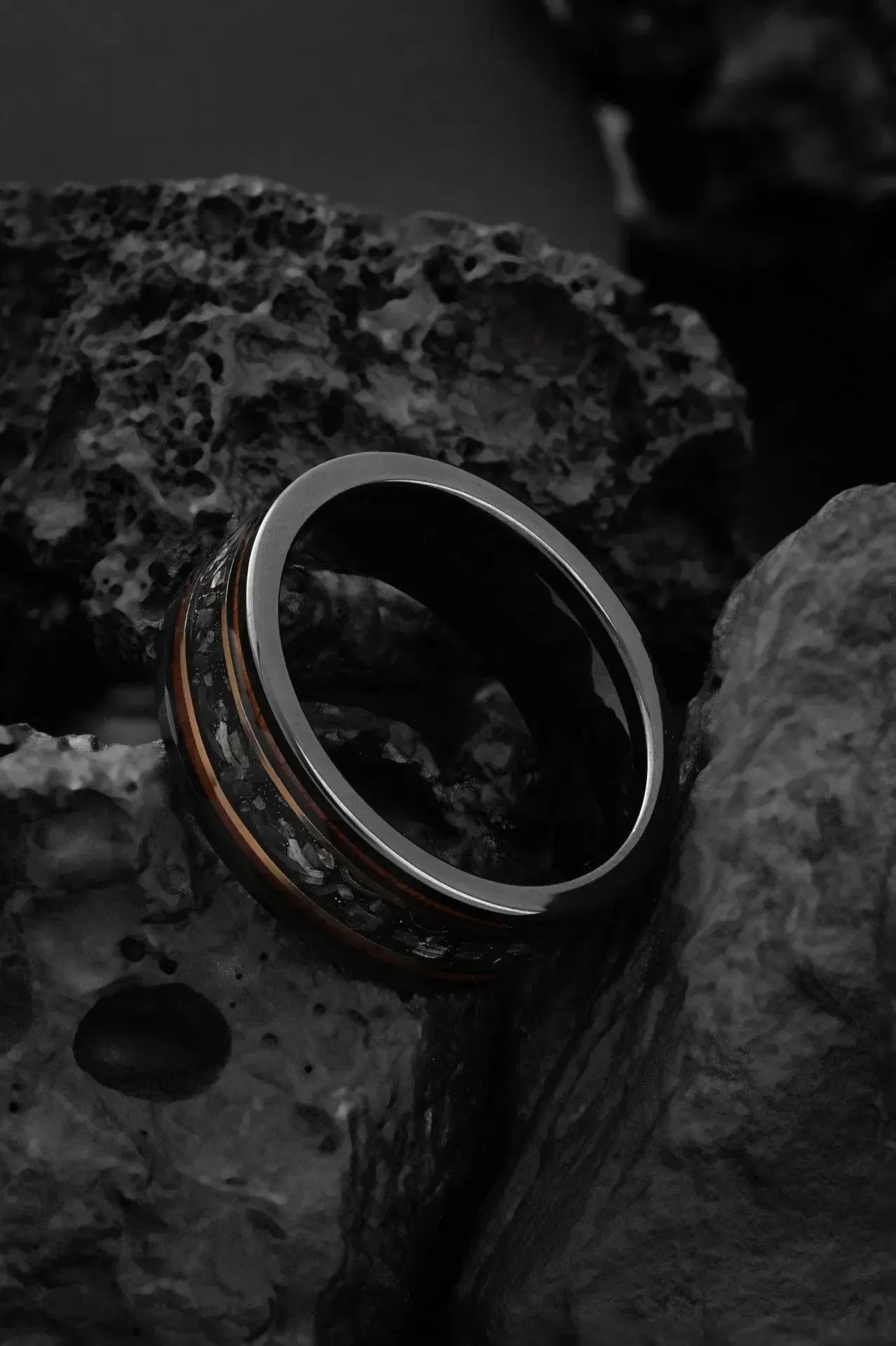 Black tungsten ring with meteorite chunks, featuring a sleek design by Regalia Rings called The Draco.
