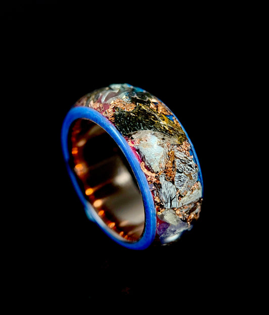 The Eurus ring featuring a mosaic inlay of purple amethyst, dinosaur bone, meteorite, and tellurium copper.