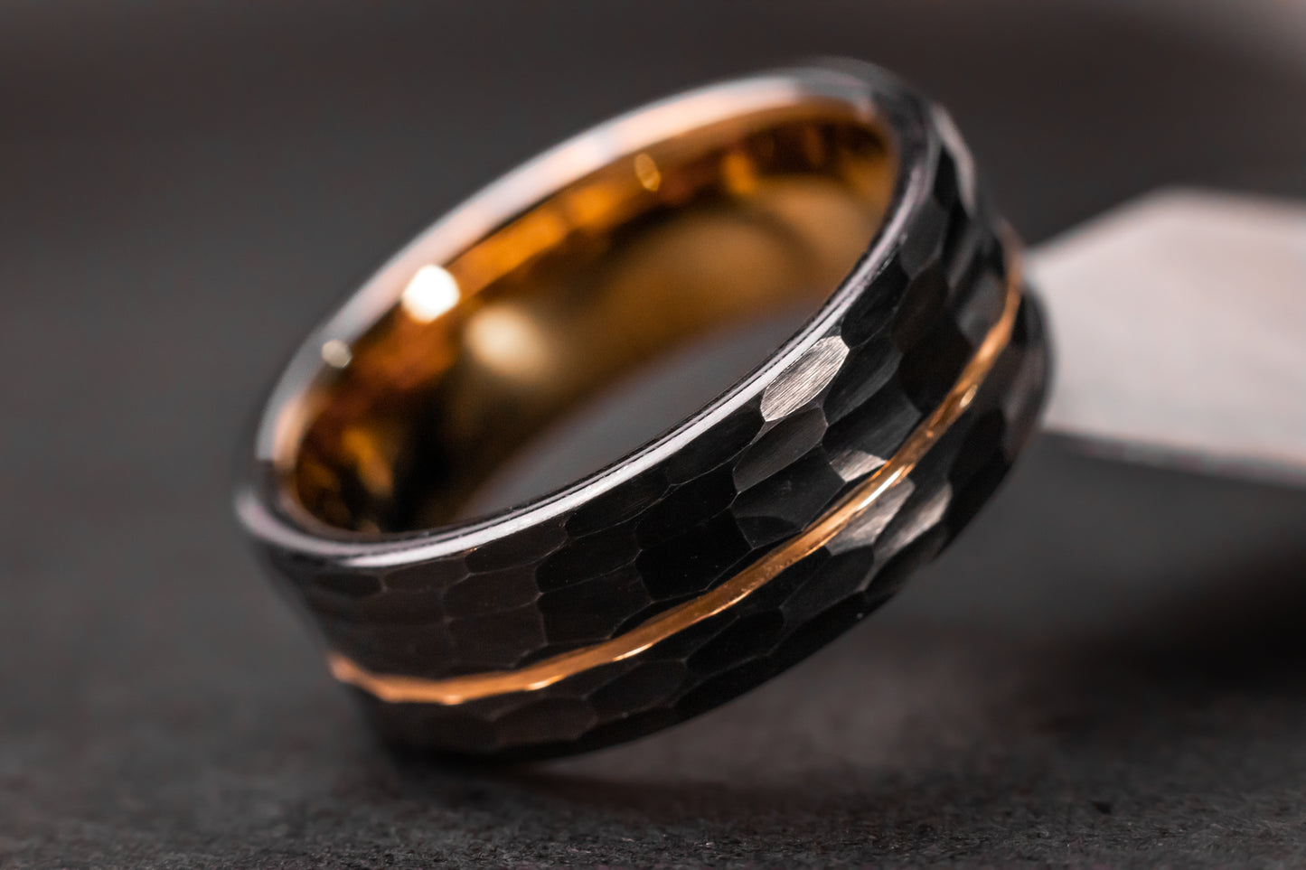 Black ring with rose gold accents on a dark background