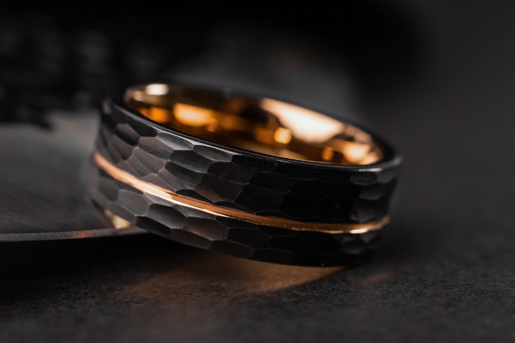 Black and gold ring on a dark surface