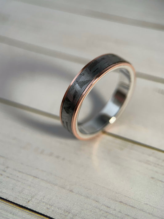 Close up of the Widmanstätten pattern on a meteorite ring with a polished copper accent and sterling silver edges.