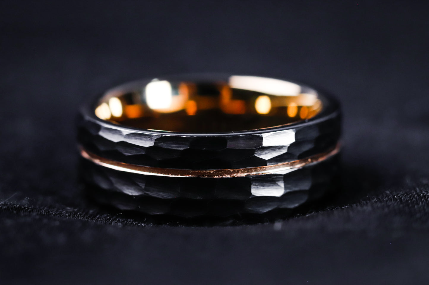 Two black rings with gold accents on a dark background
