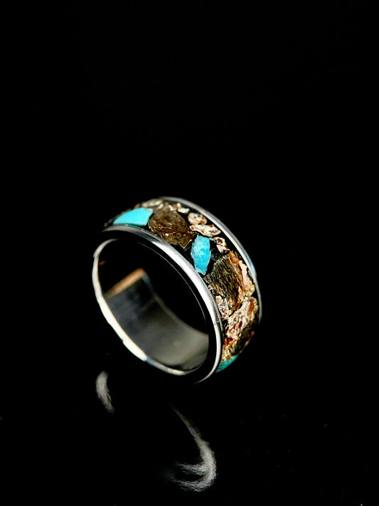 The Leviathan titanium ring featuring a mosaic inlay of Megalodon tooth, dinosaur bone, and meteorite.