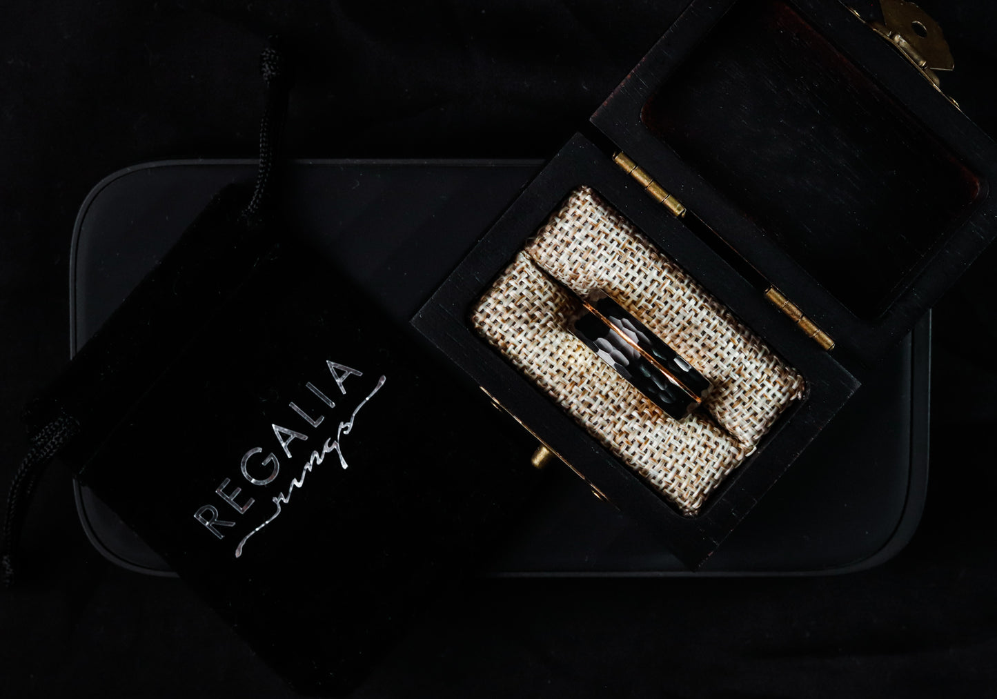 Luxury belt with decorative buckle in a black box labeled 'Regalia' on a dark background