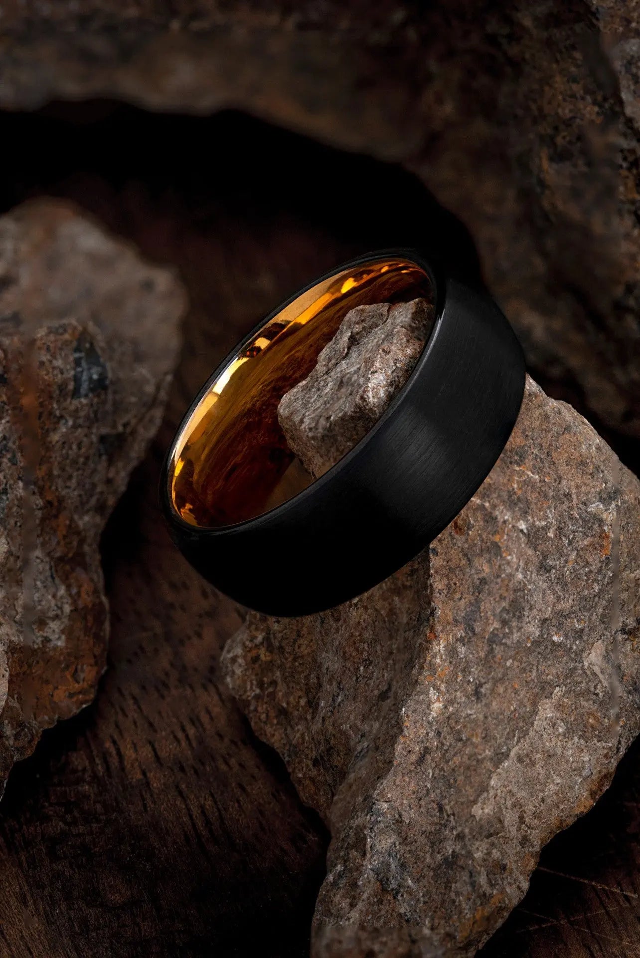Man wearing The Aquila, a scratch-resistant black and rose gold wedding ring.