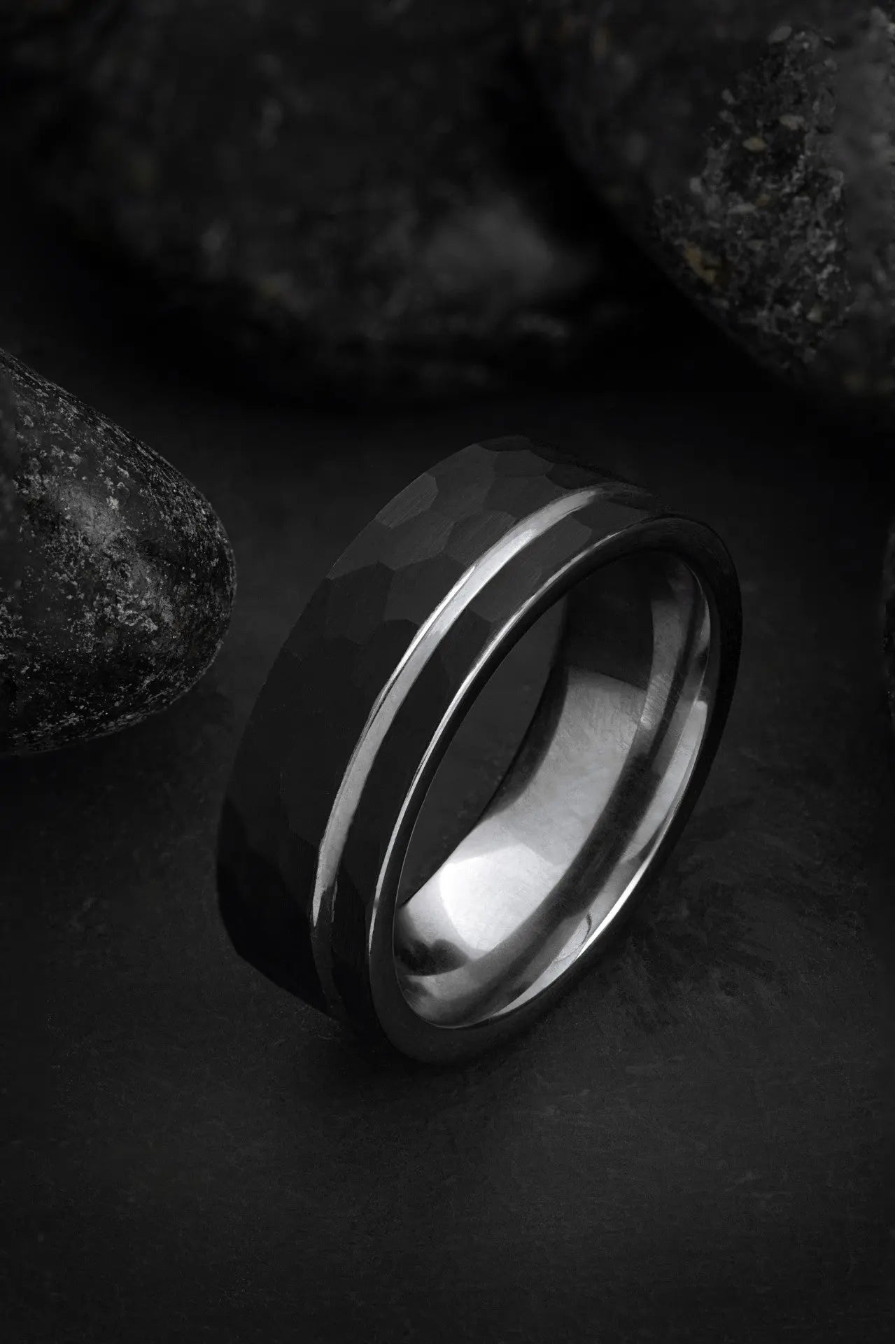 The Hermes hammered black tungsten ring featuring an offset grey inlay and polished silver interior.