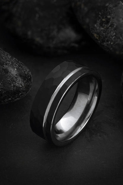 The Hermes hammered black tungsten ring featuring an offset grey inlay and polished silver interior.