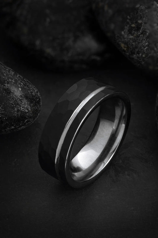 The Hermes hammered black tungsten ring featuring an offset grey inlay and polished silver interior.