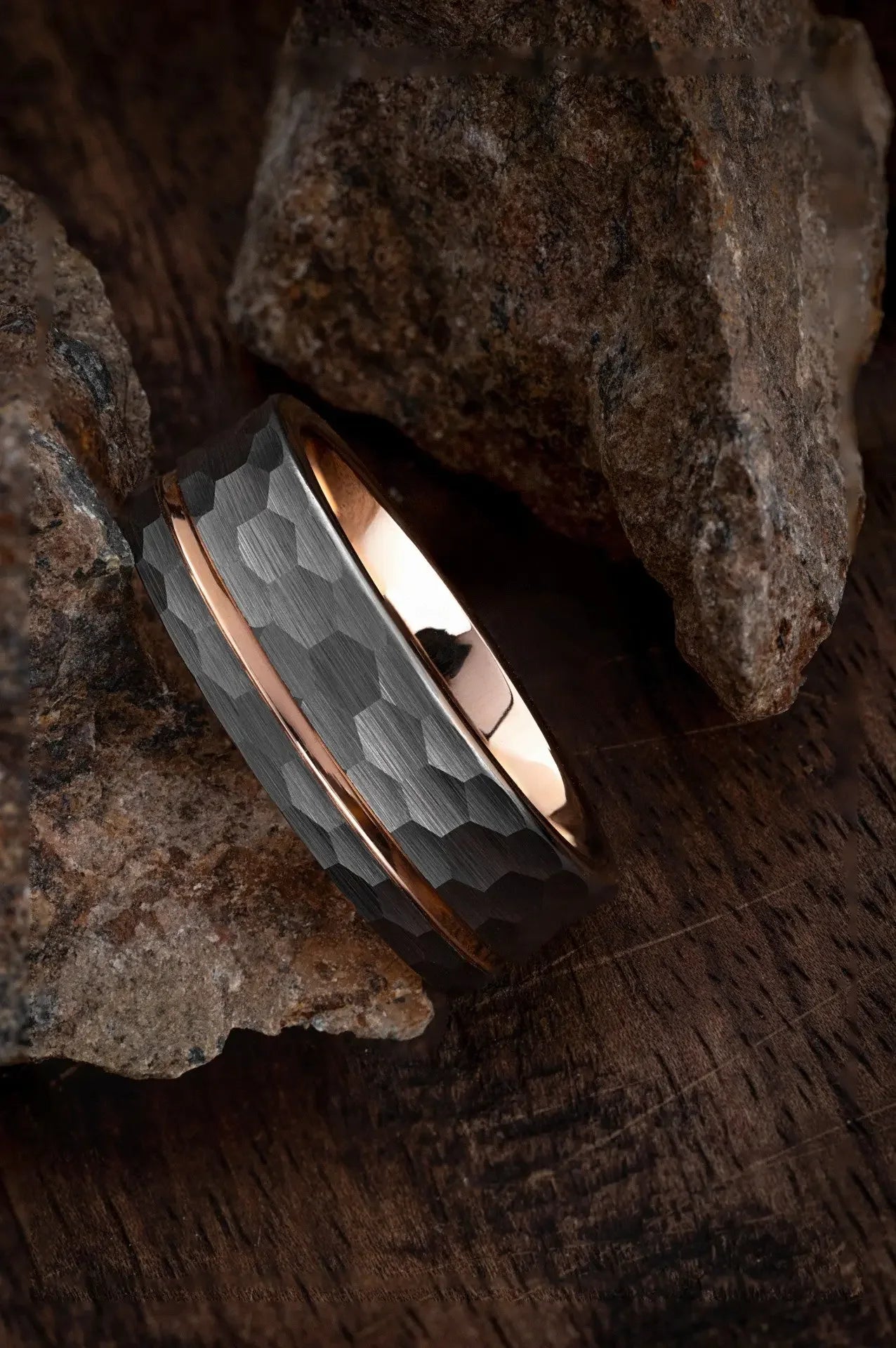 Hammered black tungsten ring with rose gold channel and interior, designed by Regalia Rings for a stylish, modern look.