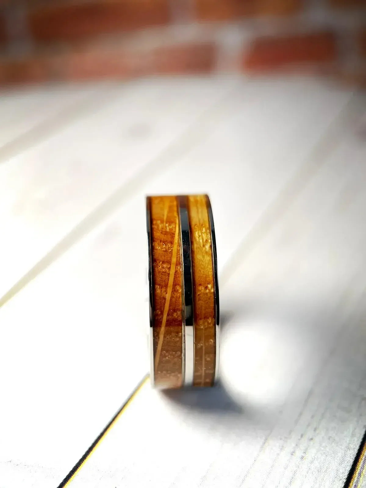 Regalia Rings The Asclepius whiskey barrel and titanium healing ring, showcasing intricate craftsmanship and detailed design.
