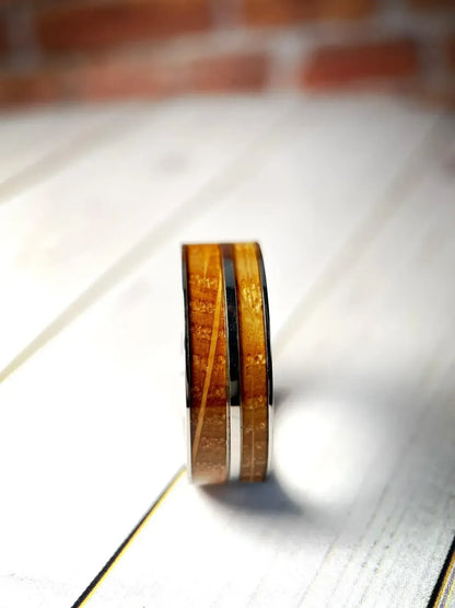 Regalia Rings The Asclepius whiskey barrel and titanium healing ring, showcasing intricate craftsmanship and detailed design.
