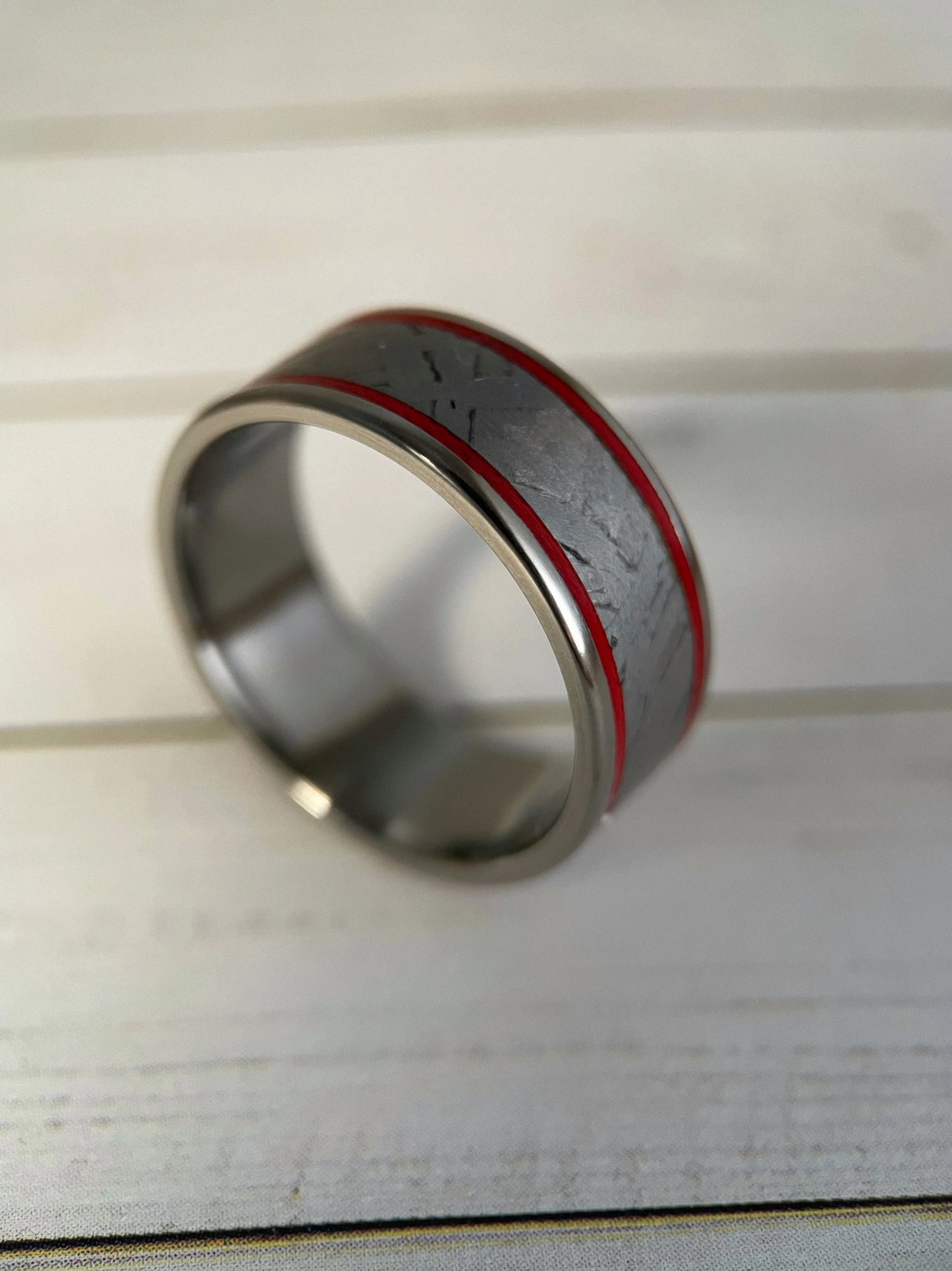 The Orion Muonionalusta meteorite and titanium Grade 5 ring by Regalia Rings, showcasing a sleek band with meteorite inlay and polished finish.