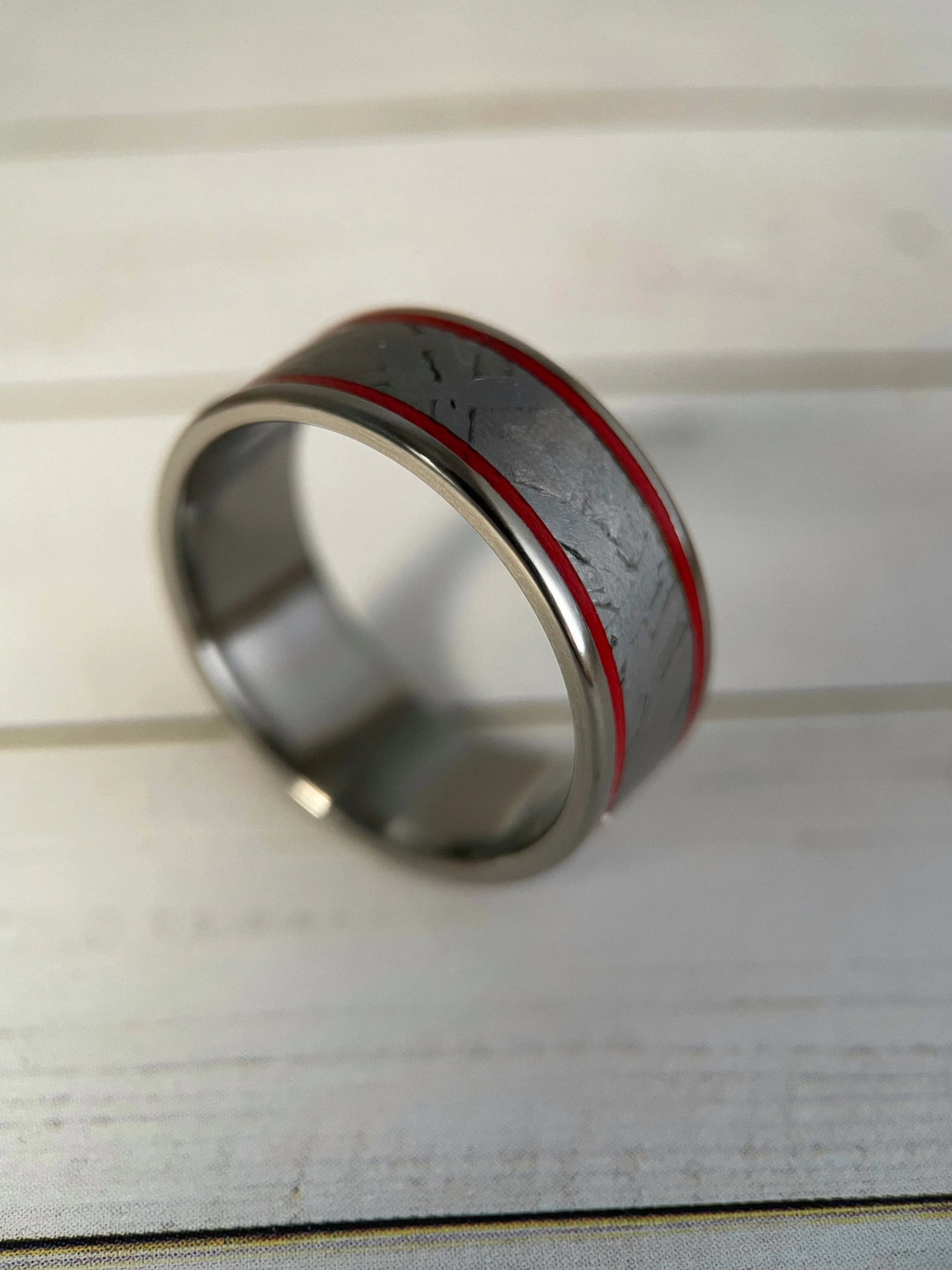 The Orion Muonionalusta meteorite and titanium Grade 5 ring by Regalia Rings, showcasing a sleek band with meteorite inlay and polished finish.