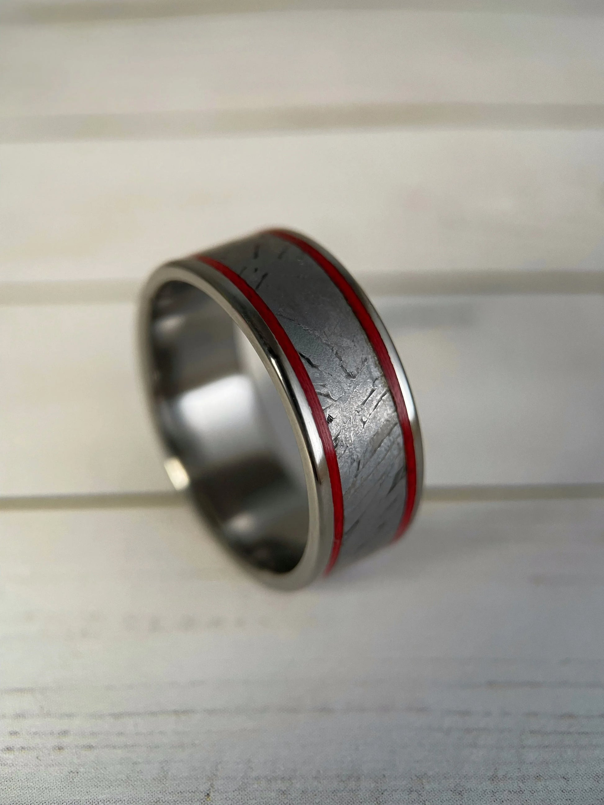 The Orion titanium Grade 5 ring by Regalia Rings featuring a Muonionalusta meteorite inlaid on a sleek band.