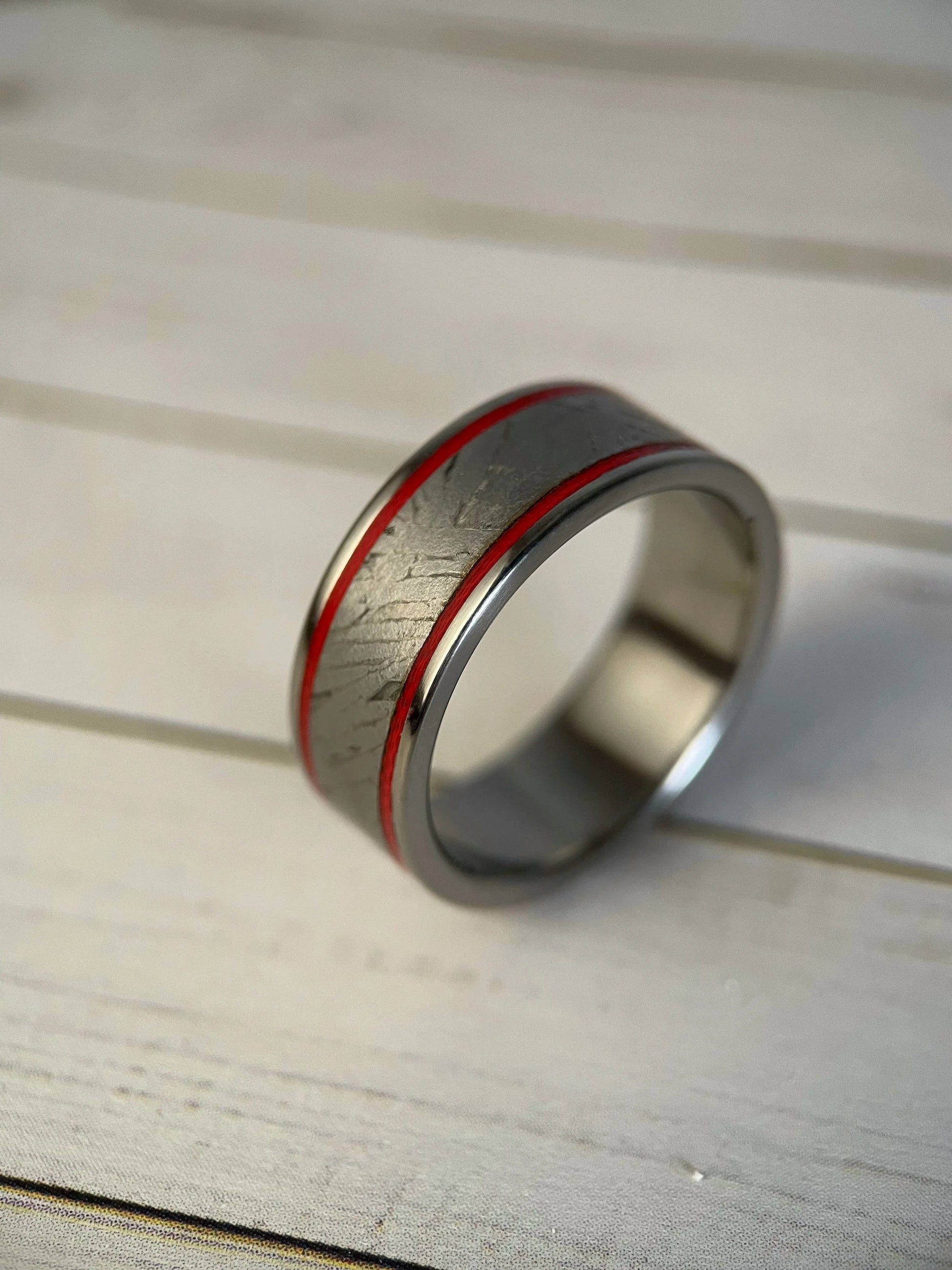 Close-up of Regalia Rings' The Orion titanium Grade 5 ring featuring Muonionalusta meteorite inlay, showcasing a sleek, modern design.