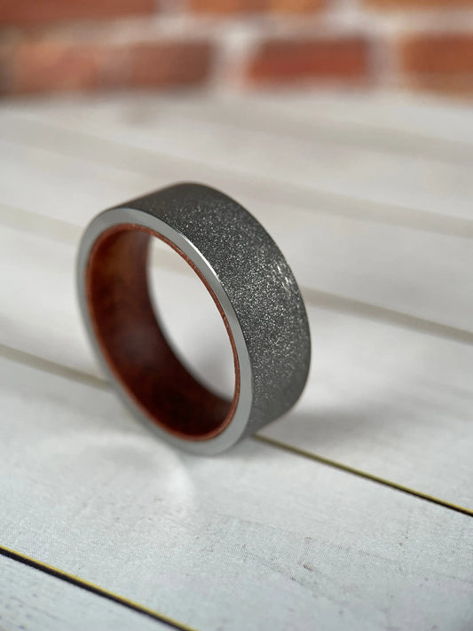 Regalia Rings The Prometheus Redwood Liner with Sandblasted Tungsten Band, showcasing detailed wood inlay and textured matte finish.