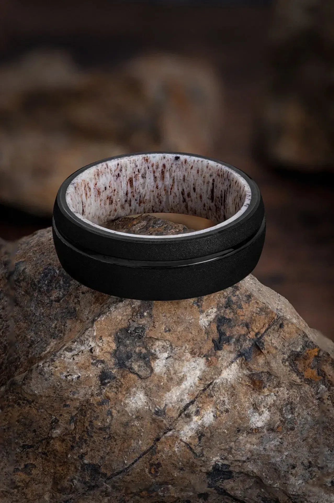 Black tungsten ring with deer antler inlay from Regalia Rings' The Zeus collection, showcasing a sleek and rugged design.
