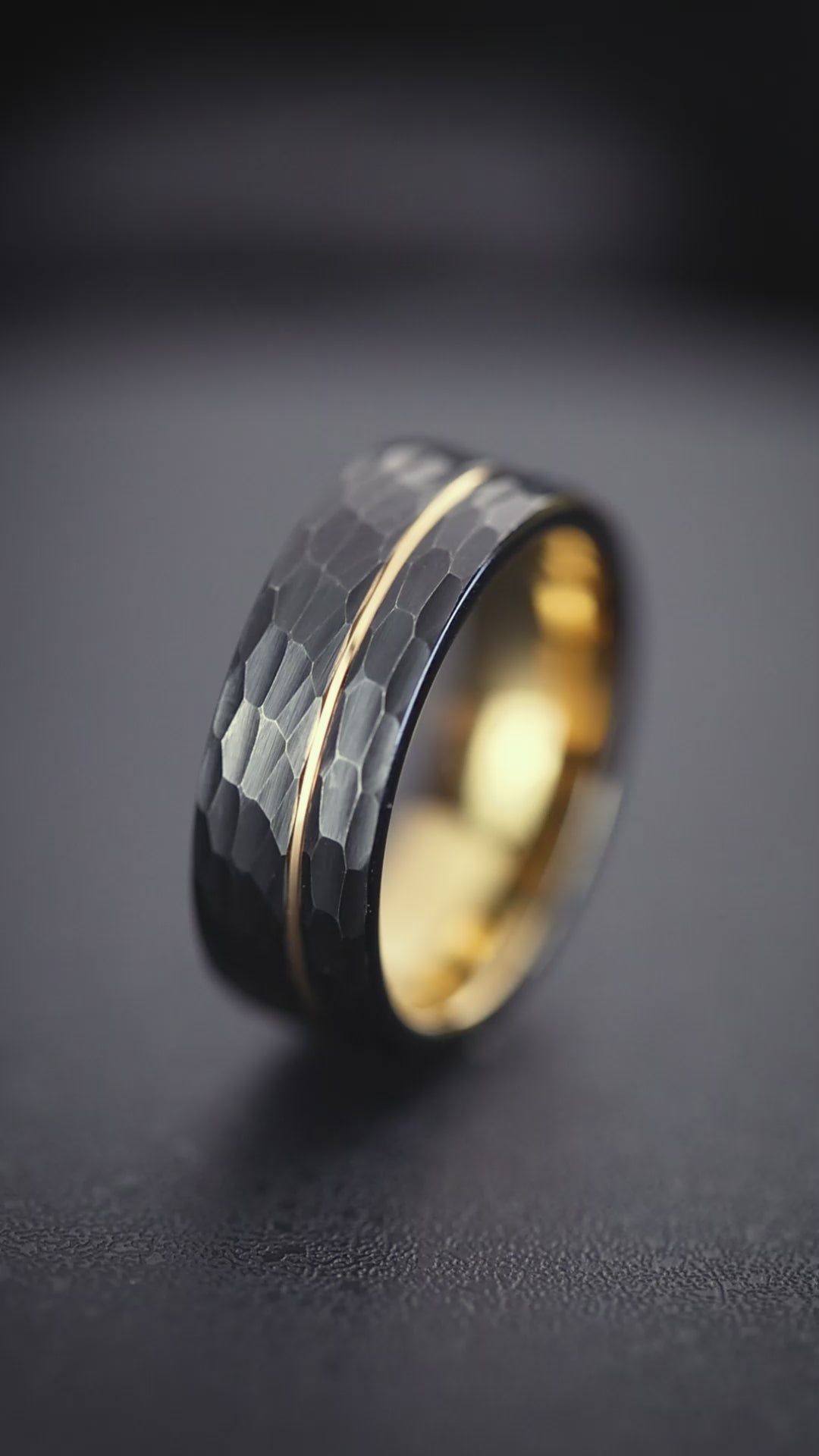 The Canopus hammered black tungsten ring featuring a rose gold offset inlay, resistant to ferric chloride.